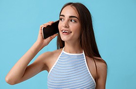 Young woman with gaps between her teeth talking on phone