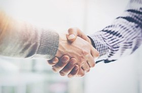 Two men shaking hands in professional setting