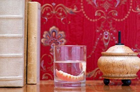 Dentures in cup of water on tabletop