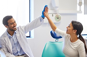 Patient giving high-five to her dentist