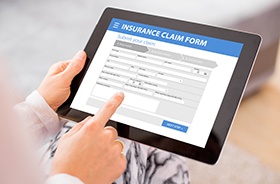 Person filling out insurance claim form on tablet