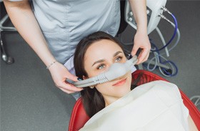 Dental team member placing nasal mask on patient