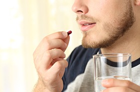 Man preparing to swallow sedative pill