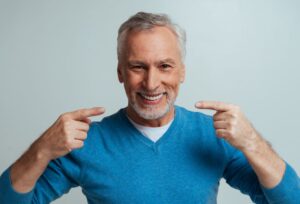 Happy senior man pointing at his smile