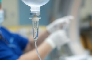 IV drip in foreground, dental team member in background